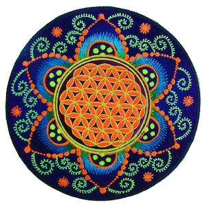 Könnte beinhalten: Runder, gestickter Aufnäher mit einem orangefarbenen Flower-of-Life-Design in der Mitte. Der Aufnäher hat einen dunkelblauen Hintergrund mit orangefarbenen, grünen und blauen Akzenten. Das Design umfasst Wirbel und Punkte.