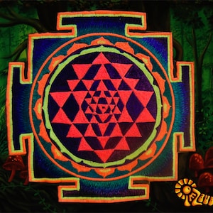May include: Embroidered patch featuring a Sri Yantra design with a geometric pattern in red, blue, and green. The patch has an orange border and is set against a forest backdrop with mushrooms and the text "Zauberwald".
