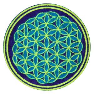 May include: A round embroidered patch featuring a geometric flower of life design. The patch has a dark blue background with a light blue and yellow-green floral pattern. The border is a yellow-green color.