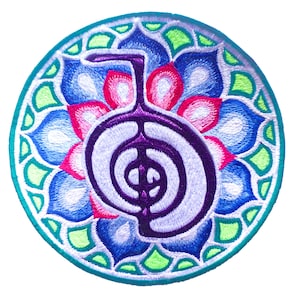Puede incluir: Parche bordado circular con un símbolo Reiki en morado y blanco, sobre un fondo de diseño floral azul, rosa y verde. El parche tiene un borde turquesa, adecuado para ropa o accesorios.
