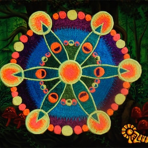 Könnte beinhalten: Ein farbenfrohes Stickdesign mit einem zentralen Sternmuster mit orangefarbenen, blauen und grünen Elementen. Das Design ist vor einem dunklen Waldhintergrund mit Pilzen und dem Text "Zauberwald" platziert.