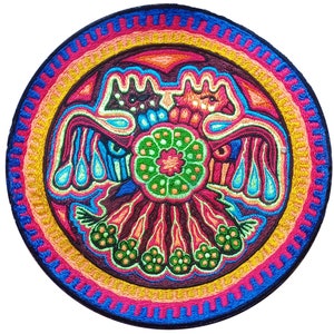 Pode incluir: Uma tapeçaria de parede circular bordada com um design colorido que apresenta dois pássaros estilizados com asas abertas, uma flor central e uma borda circundante de círculos concêntricos.