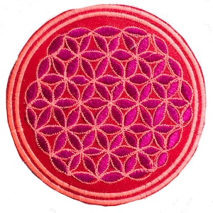 Pode incluir: Um patch redondo bordado em vermelho, com um design geométrico da flor da vida em tons de rosa e vermelho. O patch tem uma borda dupla com uma cor vermelha mais clara. O design é centrado.