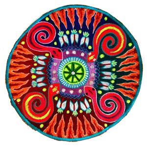 Pode incluir: Patch bordado circular com um design vibrante. O patch apresenta uma borda turquesa, que envolve um padrão complexo de elementos vermelhos, laranja, azul, roxo e verde. Duas cobras vermelhas com detalhes em amarelo se enrolam em torno do design central.