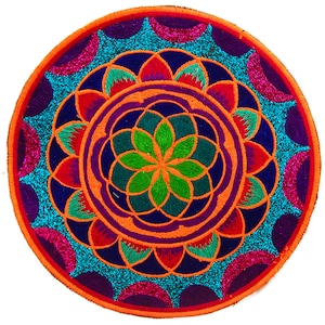 May include: A round, embroidered mandala in vibrant colors. The design features concentric circles with intricate patterns in orange, purple, teal, green, and red. The outer edge is orange, and the background is white.