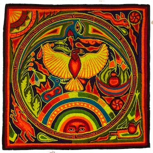 Puede incluir: Una obra de arte bordada colorida que representa un pájaro estilizado con las alas extendidas, rodeado de patrones y símbolos geométricos. La obra presenta un arcoíris, un sol con cara y otros diseños abstractos.
