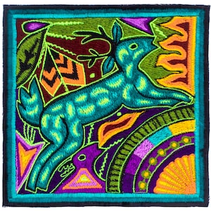 May include: Square, embroidered textile art featuring a teal deer with yellow spots leaping across a colorful landscape. The design includes orange, purple, green, and yellow elements, all framed by a teal border. The artwork is detailed and vibrant.