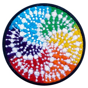 Könnte beinhalten: Runder, gestickter Aufnäher mit Regenbogenfarben. Das Design zeigt ein Spiralmuster mit weißen Akzenten, umgeben von einem schwarzen Rand. Farben sind Rot, Orange, Gelb, Grün, Blau und Lila.
