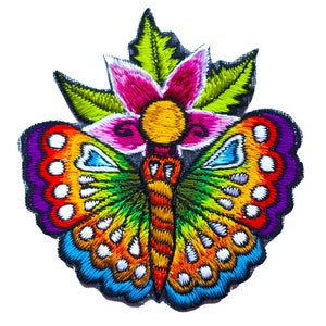 Pode incluir: Uma borboleta bordada colorida com um design floral. A borboleta é feita de cores do arco-íris e tem um corpo verde. A flor é rosa com um centro amarelo.