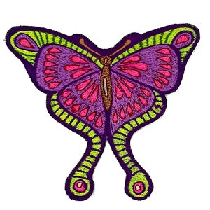 May include: Embroidered butterfly patch featuring a vibrant design. The butterfly has purple wings with pink and green accents. The patch is outlined in a dark purple color, with a detailed, textured appearance.