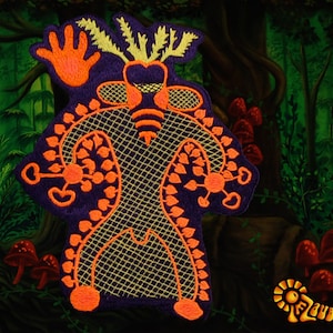 Könnte beinhalten: Ein gestickter lilafarbener Patch mit einer stilisierten menschlichen Figur in einer Waldlandschaft. Die Figur ist orange umrandet und hat ein gelbes und oranges Design. Die Figur hat eine erhobene Hand und ist von grünem Laub umgeben.