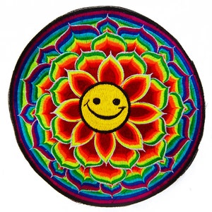 Puede incluir: Un parche redondo bordado con una cara amarilla sonriente en el centro de un diseño floral colorido. Los pétalos son rojos, naranjas, amarillos, verdes, azules y morados. El parche tiene un borde negro.