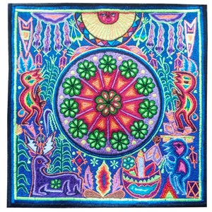 Pode incluir: Uma obra de arte bordada colorida que retrata um desenho circular com flores verdes e um centro vermelho, rodeado por várias figuras e símbolos em um fundo azul.