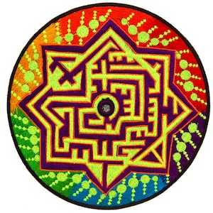 May include: Embroidered patch featuring a geometric maze design in a star shape, with a circular border. The patch uses a vibrant color palette of green, purple, orange, and blue. The design includes a central circle and a complex maze pattern.