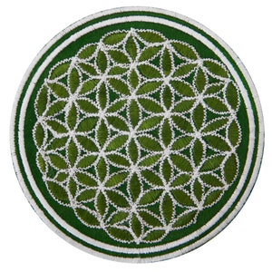 Puede incluir: Parche bordado circular con un diseño floral verde y blanco. El parche tiene un borde verde oscuro con una franja blanca y un borde exterior blanco. El diseño central es un patrón repetido de hojas verdes con costuras blancas.