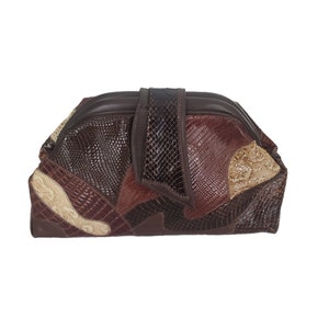 May include: A brown patchwork clutch with a flap closure. The bag features a variety of textures and shades of brown, including faux snakeskin and smooth leather. The clutch is rectangular and appears to be a vintage or retro style.