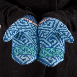 May include: A pair of blue knitted mittens with a geometric pattern. The mittens have a green band around the wrist.