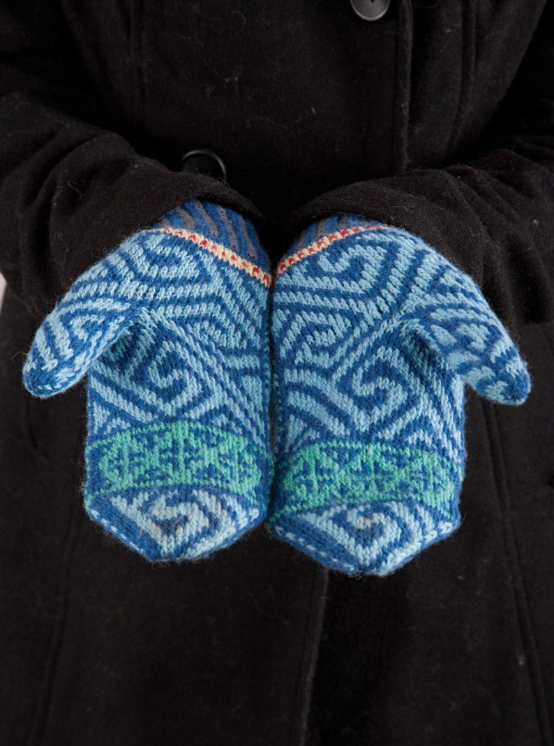 May include: A pair of blue knitted mittens with a geometric pattern. The mittens have a green band around the wrist.