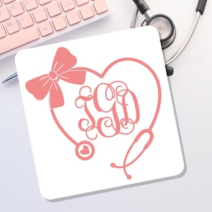 May include: A white square mousepad featuring a pink heart-shaped stethoscope design with a bow and initials. The design includes a heart-shaped stethoscope with the initials "SGD" in a decorative font. A pink keyboard and stethoscope are in the background.
