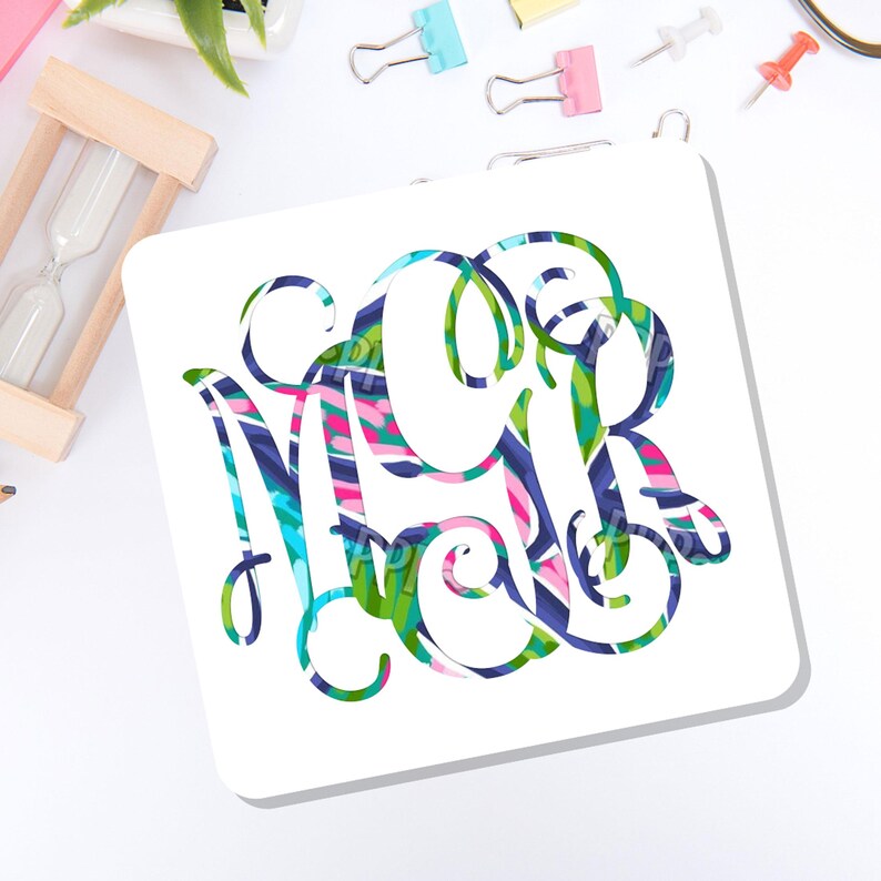May include: A square white coaster featuring a large, decorative monogram with the letters M, C, and R intertwined. The letters are filled with a vibrant, multi-colored abstract pattern in shades of blue, green, pink, and white with swirling lines.