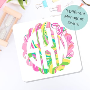 May include: A square coaster featuring a scalloped circular design with a vibrant pink, yellow, and green abstract pattern. The center displays a white monogram with the letters SKW. A light blue circle contains the text 9 Different Monogram Styles!
