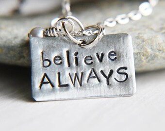 Könnte beinhalten: Eine silberne Halskette mit einem Anhänger, auf dem "believe ALWAYS" steht.