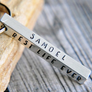 May include: Silver keyring with a rectangular bar engraved with the text "Samuel Best Life Ever".