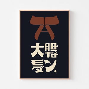 Puede incluir: Un estampado artístico enmarcado con un diseño minimalista. La obra de arte incluye una forma abstracta marrón en la parte superior y caracteres japoneses en blanco y beige sobre un fondo azul oscuro. El marco es de color marrón claro.