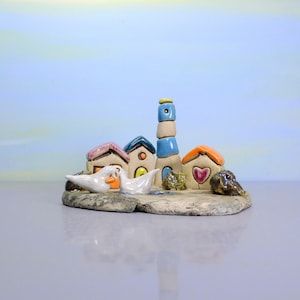 Ceramic sculpture (Keramik, töpferwaren) of miniature island with houses, a lighthouse and two swans