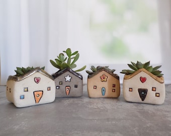 Random ceramic planter shaped as a house or a house decor, made with different kinds of clay and decorations. Plant IS NOT included