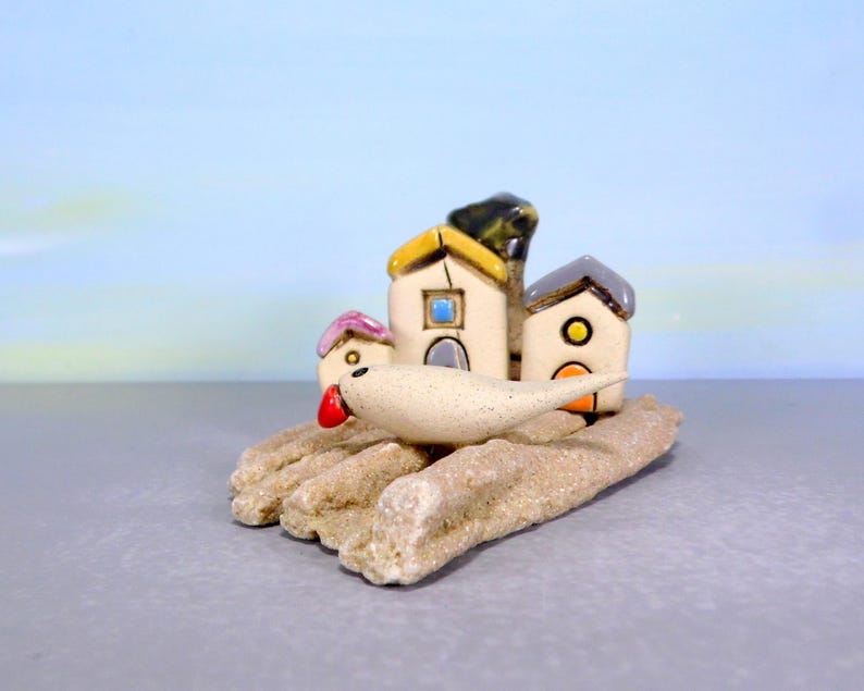 Whimsical white miniature ceramic houses with anOlive tree on a unique beach stone image 3