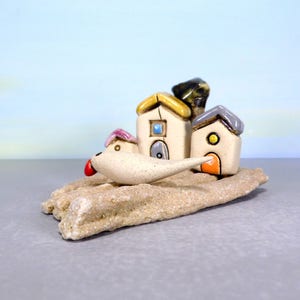 Whimsical white miniature ceramic houses with anOlive tree on a unique beach stone image 4