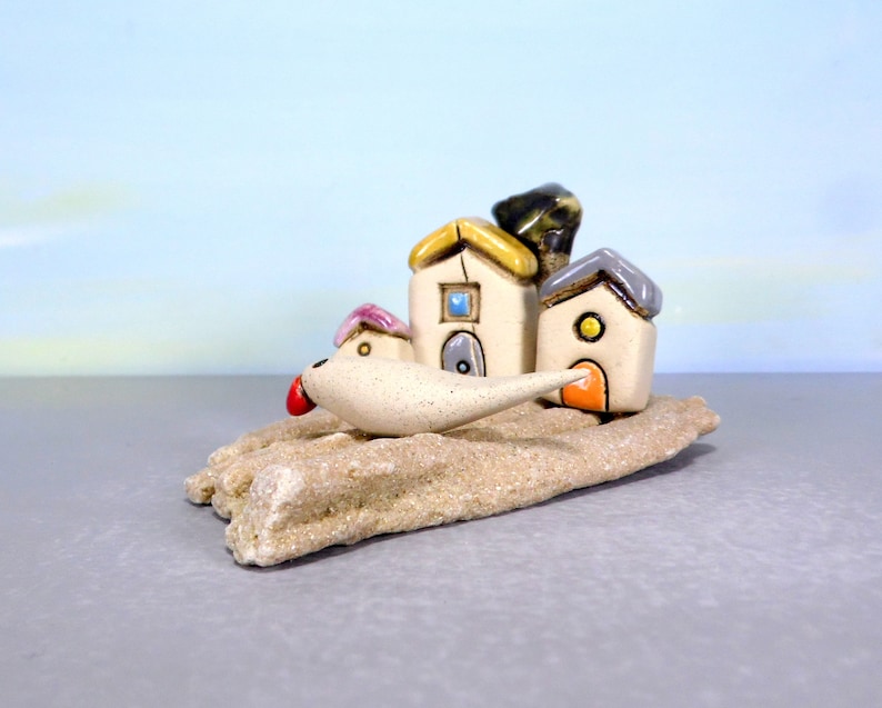 Whimsical white miniature ceramic houses with anOlive tree on a unique beach stone image 4