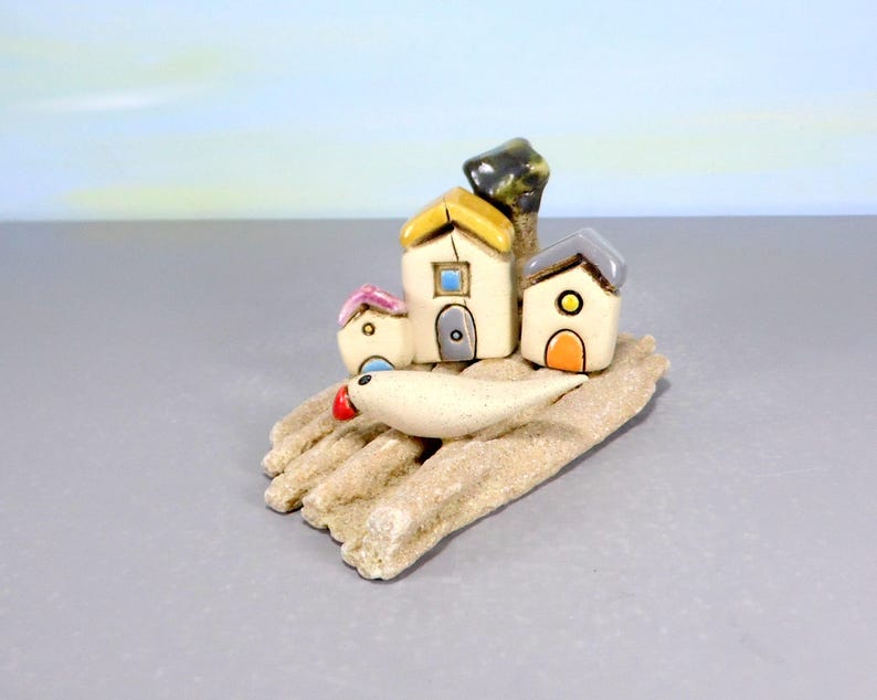 Whimsical white miniature ceramic houses with anOlive tree on a unique beach stone image 5