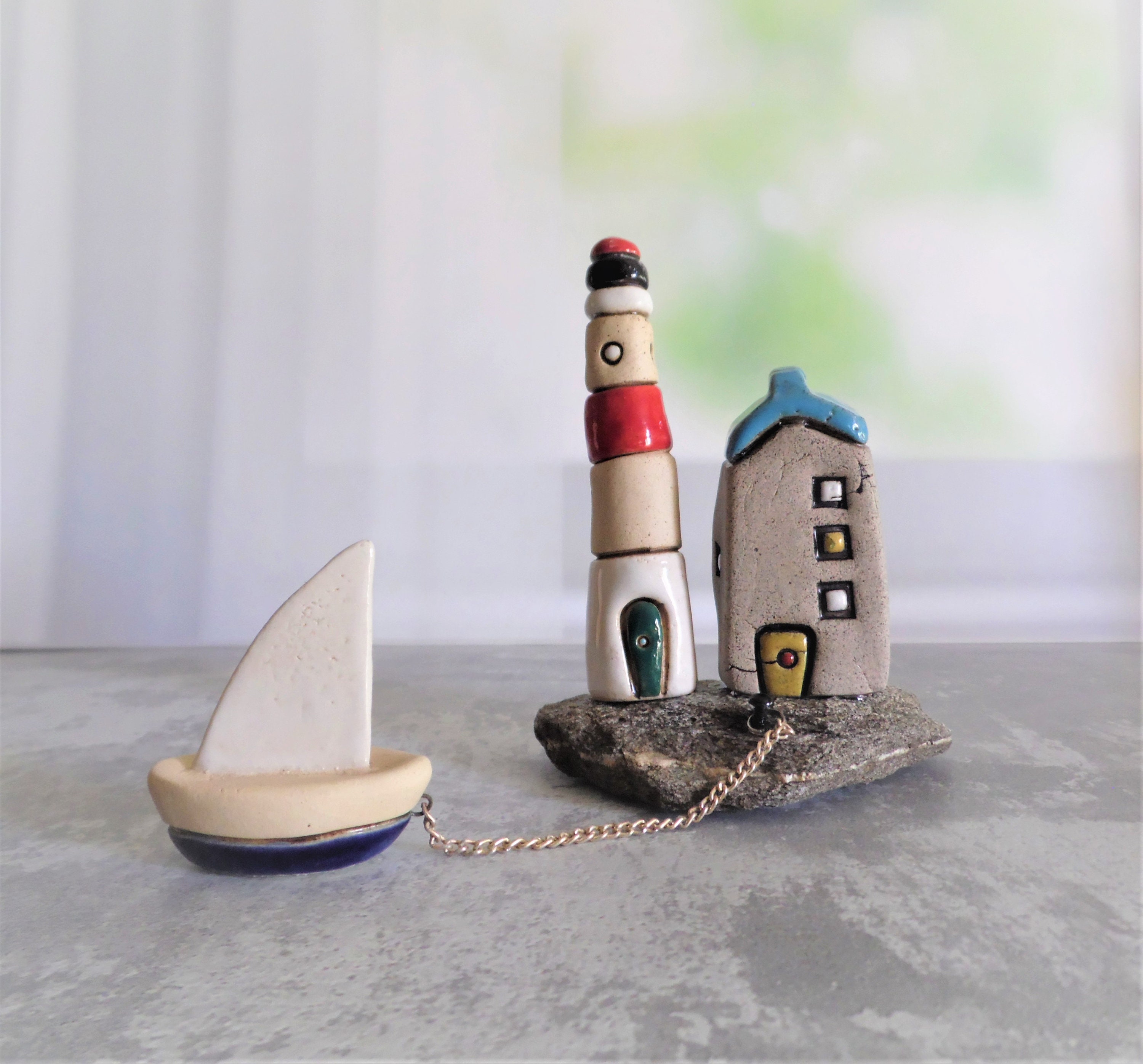 Small ceramic lighthouse sculpture with a houses and a little Etsy