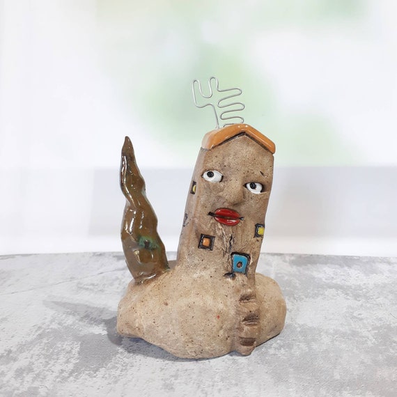 Small Ceramic Sculpture of a Brown Clay House With Human Face, an Antenna  and a Tree Beside It on a Clay Hill, Art Object 