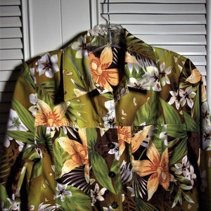 May include: A green, brown, and white floral print jacket with a button closure. The jacket has a collar and long sleeves.