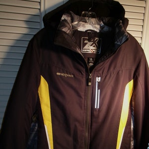 May include: Black and yellow ski jacket with a white zipper and a logo that says "ZeroXPosure" on the front.