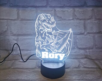 May include: A white 3D printed dinosaur night light with the name "Rory" printed on the base. The light is on and illuminating the dinosaur.