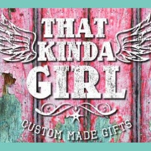May include: A pink wooden sign with white distressed lettering that reads "That Kinda Girl" with wings on either side. The sign also has the text "Custom Made Gifts" at the bottom.