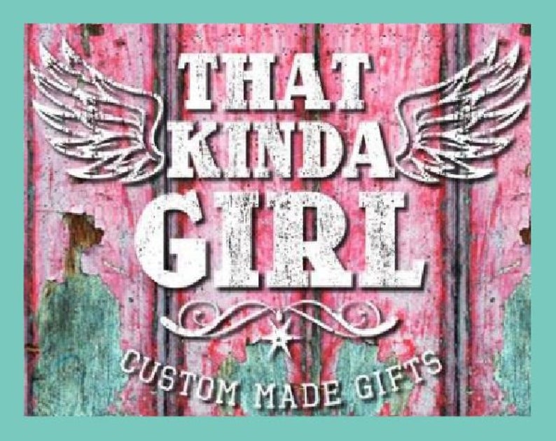May include: A pink wooden sign with white distressed lettering that reads "That Kinda Girl" with wings on either side. The sign also has the text "Custom Made Gifts" at the bottom.