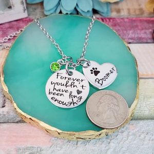 May include: Silver necklace with a green crystal charm, a round charm with the text "Forever wouldn't have been long enough" and a heart charm with a paw print and the text "Boomer".