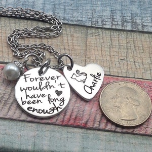 May include: Silver necklace with a round charm that says "Forever wouldn't have been long enough" and a heart charm with a cat silhouette and the name "Charlie" engraved on it.