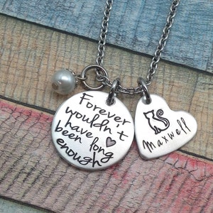 May include: Silver necklace with a heart charm that says "Maxwell" and a round charm that says "Forever wouldn't have been long enough". A small pearl charm hangs from the necklace.