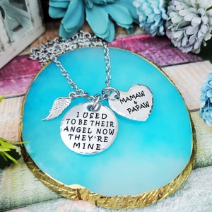 May include: Silver necklace with two charms. One charm is a heart with the text "Mamaw & Papaw". The other charm is a circle with the text "I used to be their angel now they're mine".