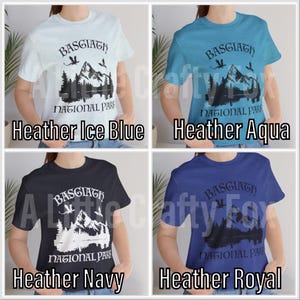 May include: Four heather t-shirts in ice blue, aqua, navy, and royal blue. Each shirt features a mountain and lake graphic with the text "BASGIATH NATIONAL PARK". The shirts are short-sleeved.