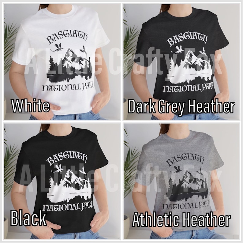 May include: A collection of four t-shirts in white, dark grey heather, black, and athletic heather. Each shirt features the text "BASGIATH NATIONAL PARK" with a mountain and forest graphic. The shirts are short-sleeved.