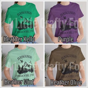 May include: Four t-shirts in different colors: Heather Kelly green, purple, Heather Mint, and Heather Olive. Each shirt features a mountain and forest graphic with the text "BASGIATH NATIONAL PARK".