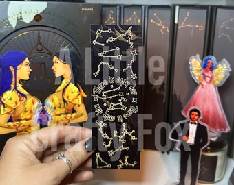 May include: A black bookmark with gold foil accents features a constellation design and the text "There is only her there is only him".