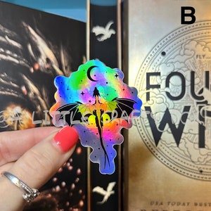 May include: A holographic sticker featuring a rainbow-colored dragon flying in a starry sky with a crescent moon. The sticker is on a white background.